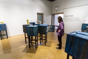 photo of a women interacting with the Hidden Water exhibit.