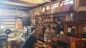 A class of college students at the MSU Museum assisting with collections items in a turn of the century general store.