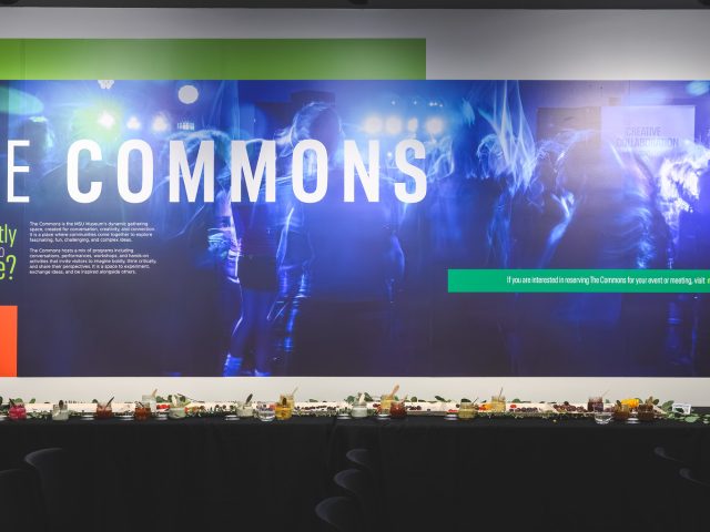 A large wall banner showcasing folks dancing in a blue duotone style hangs on the wall, with text that reads 